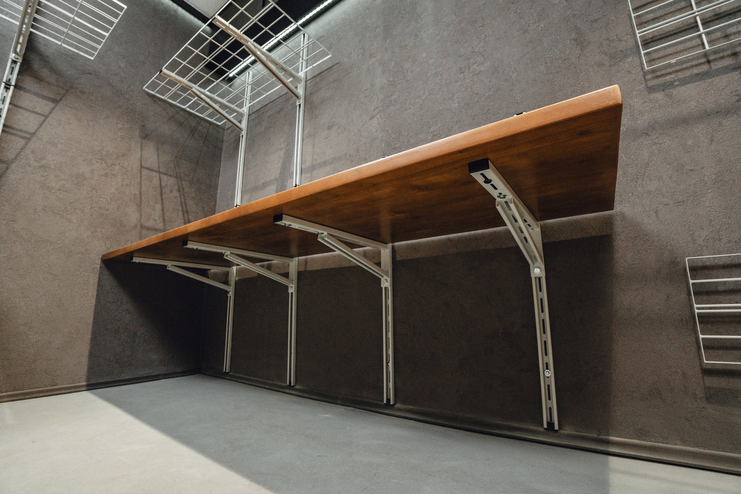 Wooden table with metal legs against a gray wall