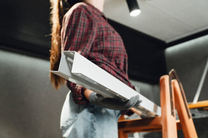 Person holding a white rectangular object in an indoor setting