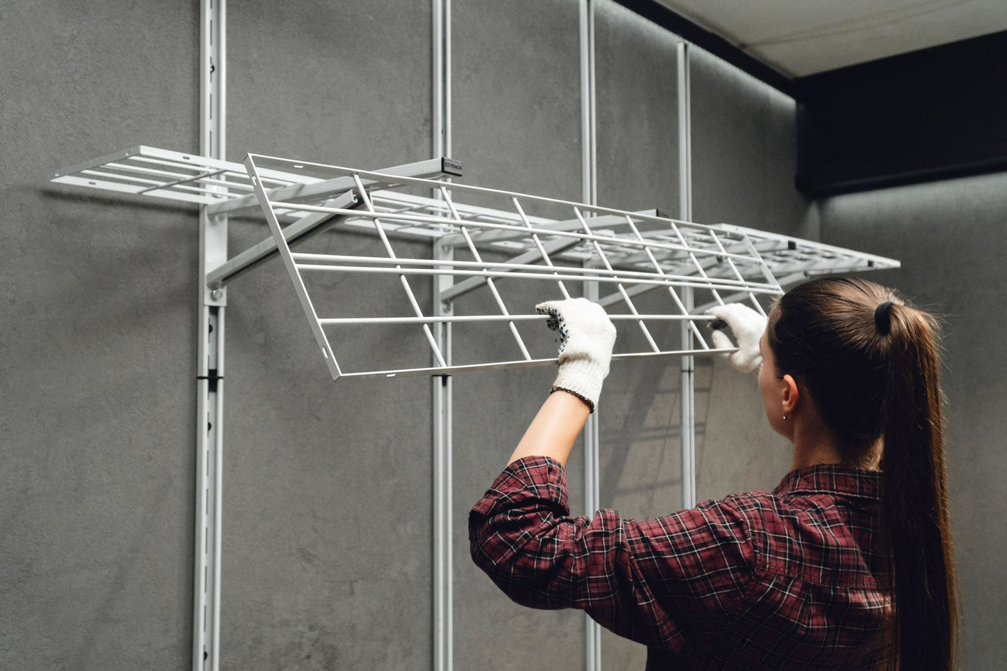 Person installing a metal grid on a wall