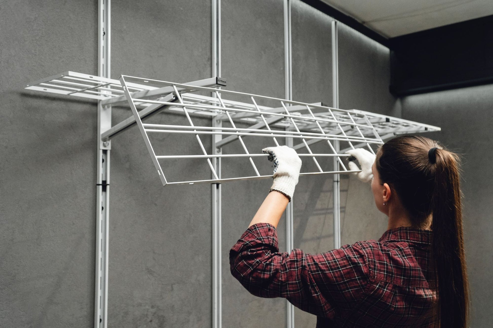 Person installing a metal grid on a wall