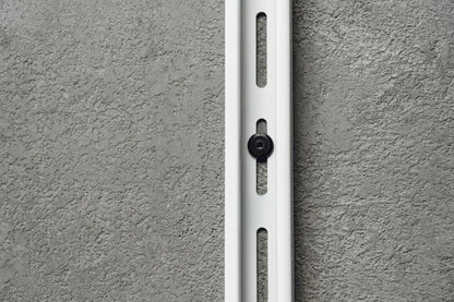 White metal bracket on a gray concrete wall