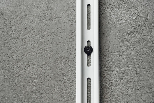 White metal bracket on a gray concrete wall