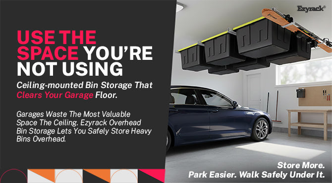 : Ezyrack overhead garage storage system with black bins and skis mounted to the ceiling above a parked car.