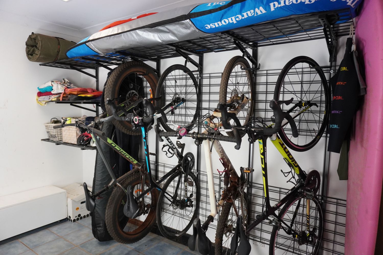 Bicycles stored on a wall-mounted bike rack in a garage.