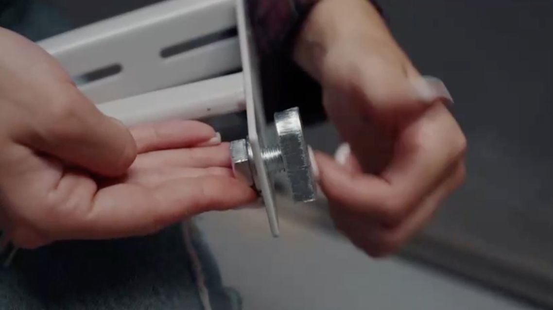 Close-up of hands adjusting a metal lock mechanism.