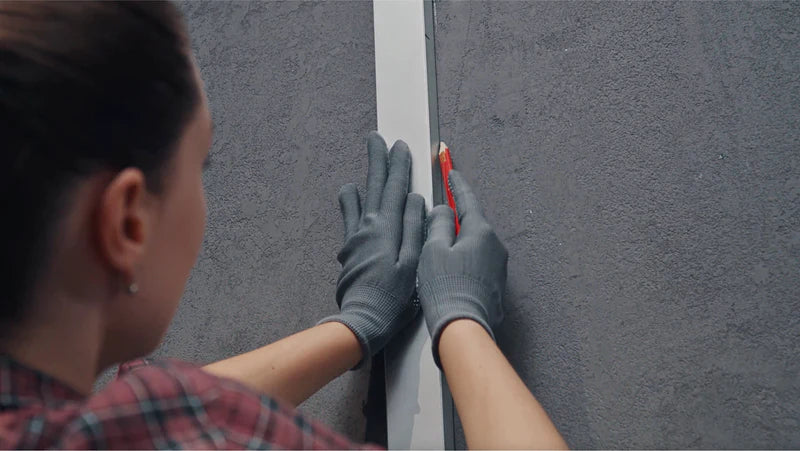 Image showing the first step of installation, demonstrating a person using a spirit level and pencil to mark accurate mounting lines on a wall.