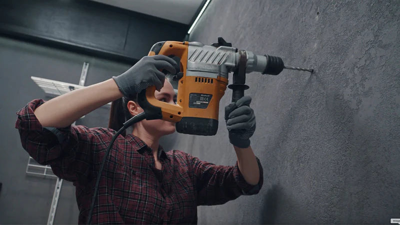 Image showing step four of the installation process, featuring a person using a power drill to create holes in a wall for wall plugs.