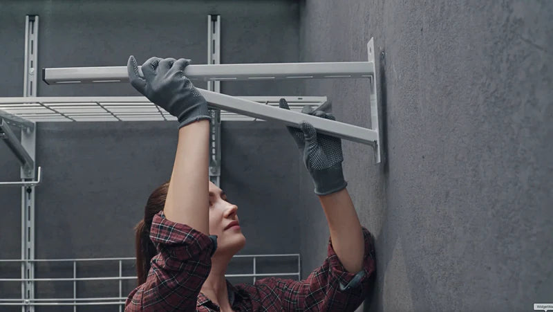 Image showing the fourth step of installation, featuring a person using a heavy-duty power drill to create a hole in a concrete wall for wall plugs.