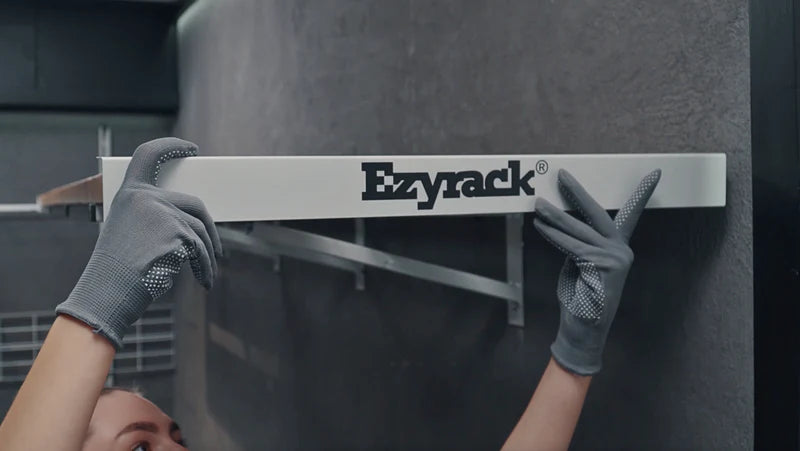 Installing an Ezyrack branded end cover to finish the edge of a wall-mounted shelving unit.