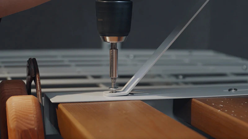 Securing an Ezyrack wall channel bracket to a wall with a power tool.