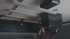 Video showing the final step of the Ezyrack Tote Master Pro installation, demonstrating the secure placement of multiple storage totes into the completed ceiling rail system.